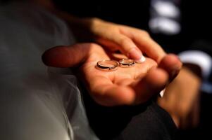 Picture of man and woman with wedding ring. Bridal rings in man's hand. Hands closeup. photo