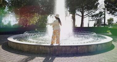 joven alegre africano mujer bailando en agua fuente en verano hora video