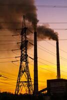 high voltage post. High-voltage tower sky background, factory pipe with smoke over it. Earth pollution concept. Industrialisation. Selective focus photo