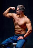 Strong bodybuilder man with perfect abs, shoulders,biceps, triceps and chest showing his biceps. Healthy body motivation. photo