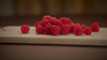 Frais biologique rouge framboises des fruits sur en bois table Contexte video