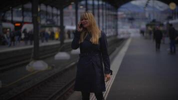 blond femme parlant en colère sur mobile téléphone à gare argumenter video