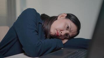 Tired woman lying on table in office relaxing at work holding laptop computer. Hard work, lazy person, business and youth concept. video