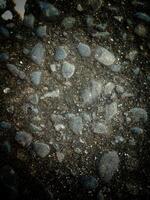 A collection of rocks scattered on the ground, varying in size, shape, color, and texture. photo