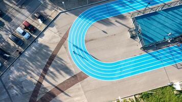 Blue running track on public sports ground aerial view photo