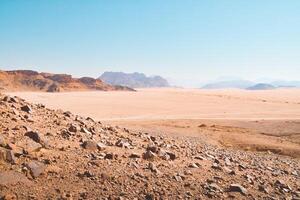 Top aerial view Wadi Rum desert in Jordan with clear blue skies and rocky terrain. photo