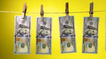 Dollars dry on a clothespin rope on a yellow background. The financial concept of the dollar. Hundred dollar bill on a rope. Money laundering concept. video