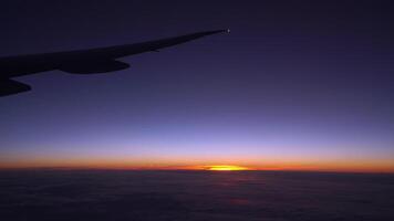 Visão a partir de a avião janela do a asa, nuvens e uma lindo pôr do sol. video