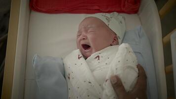 recém-nascido criança chora depois de nascimento deitado dentro berço video