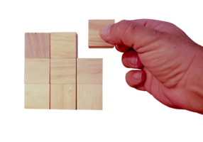 hand of adult person on transparent background placing small wooden cubes png