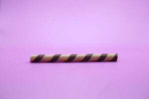 wafer stick isolated purple background. a chocolate flavored wafer stick. photo