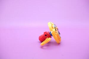 spinning top toy isolated on purple background photo