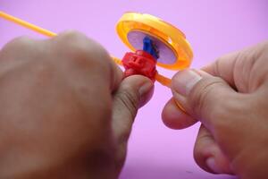 spinning top toy isolated on purple background photo