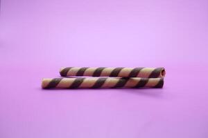 wafer stick isolated purple background. 2 chocolate flavored wafer sticks. photo