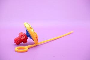 spinning top toy isolated on purple background photo