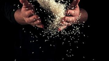 Men's hands throw handfuls of raw crumbly rice. On a black background. Filmed on a high-speed camera at 1000 fps. video