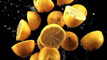 Lemon halves fly up and rotate in flight. On a black background. Filmed is slow motion 1000 fps. video