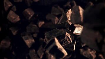 Pieces of chocolate fall down. Top view. Against a dark background. Filmed on a high-speed camera at 1000 fps. video