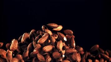 Almonds go up and fall. On a black background. Filmed is slow motion 1000 fps. video