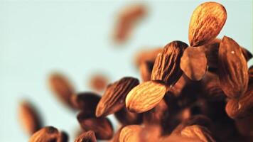 Almonds rise up and fall down. On a blue background. Filmed on a high-speed camera at 1000 fps. video