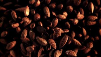 Almonds fly up and rotate in flight. Top view. Macro background. Filmed on a high-speed camera at 1000 fps. video