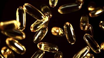 omega 3 vitamine capsules draaien in vlucht. Aan een zwart achtergrond. gefilmd Aan een hoge snelheid camera Bij 1000 fps. video