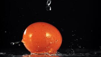 acqua goccioline autunno su il rotante uovo. su un' nero sfondo. girato è lento movimento 1000 fps. video