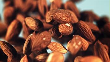 Almonds rise up and fall down. On a blue background. Filmed on a high-speed camera at 1000 fps. video