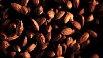 Almonds fly up and rotate in flight. Top view. Macro background. Filmed on a high-speed camera at 1000 fps. video