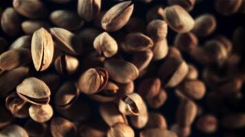 Pistachios rise up and rotate in flight. Top view. On a black background. Filmed is slow motion 1000 fps. video