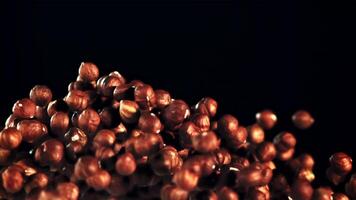 A pile of peeled hazelnuts soars upwards. On a black background. Filmed on a high-speed camera at 1000 fps. video