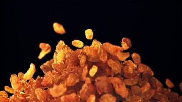 A pile of raisins soars up and falls. On a black background. Filmed is slow motion 1000 fps. video