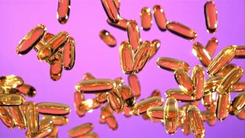 Omega 3 vitamin capsules rise and fall down. On a purple screen. Filmed is slow motion 1000 fps. video