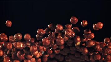 A pile of peeled hazelnuts soars upwards. On a black background. Filmed on a high-speed camera at 1000 fps. video