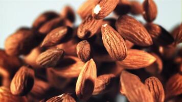 Almonds rise up and fall down. On a blue background. Filmed on a high-speed camera at 1000 fps. video