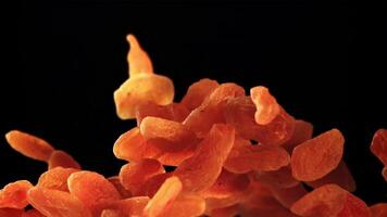 Dried apricots rise up and rotate in flight. On a black background. Filmed on a high-speed camera at 1000 fps. video