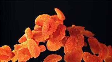 Dried apricots rise up and rotate in flight. On a black background. Filmed on a high-speed camera at 1000 fps. video