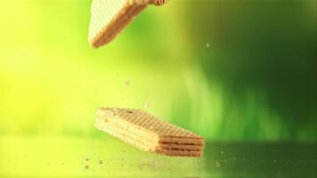 Waffles fall on the table. On a green background. Filmed on a high-speed camera at 1000 fps. video