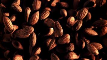 Almonds rise up and fall down. Top view. On a black background. Filmed on a high-speed camera at 1000 fps. video