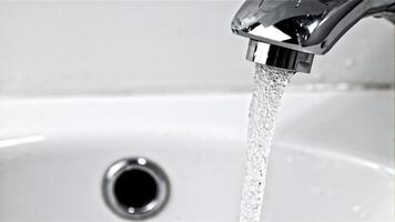 A stream of clean water pours from the tap in the bathroom. On a white background. Filmed on a high-speed camera at 1000 fps. video