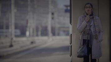 mère attendre pour fils à train station vérification le temps à consulter une regarder video