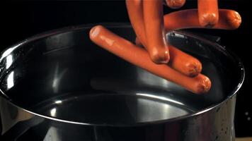 The sausages fall into a pot of water. Filmed on a high-speed camera at 1000 fps. High quality FullHD footage video