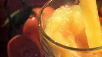 fresco tangerina suco é derramado para dentro uma vidro. filmado em uma alta velocidade Câmera às 1000 fps. Alto qualidade fullhd cenas video