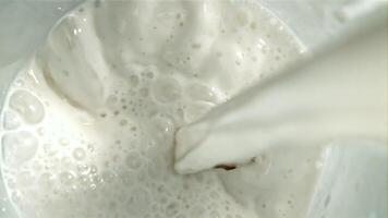 The milk is poured into a glass with splashes. Top view. Filmed on a high-speed camera at 1000 fps. High quality FullHD footage video