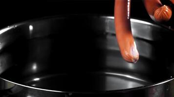 The sausages fall into a pot of water. Filmed on a high-speed camera at 1000 fps. High quality FullHD footage video