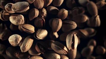 Pistachios rise up and rotate in flight. Top view. On a black background. Filmed is slow motion 1000 fps. video