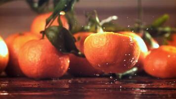 Slices of fresh tangerines fall on a wooden table. Filmed on a high-speed camera at 1000 fps. High quality FullHD footage video