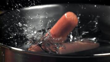 The sausages fall into a pot of water. Filmed on a high-speed camera at 1000 fps. High quality FullHD footage video