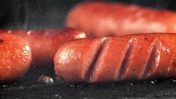 saucisses sont frit avec éclaboussures dans une poêle. filmé sur une haute vitesse caméra à 1000 ips. haute qualité Full HD métrage video