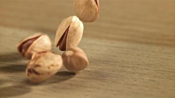 de pistachenoten vallen Aan de tafel. gefilmd Aan een hoge snelheid camera Bij 1000 fps. hoog kwaliteit full HD beeldmateriaal video